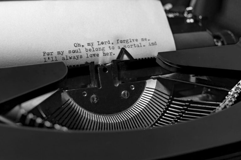 An antique typewriter with a sheet of paper being typed on