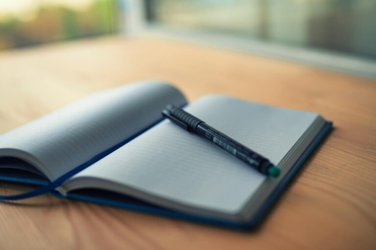 An open lined notebook with a fountain pen