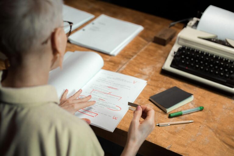 A red pen marking up a manuscript page