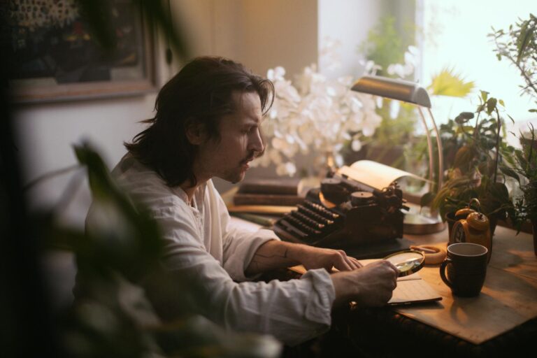 A person reading in the silhouette of a window