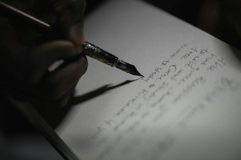 A fountain pen resting on an open notebook beside a cup of coffee