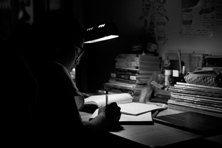 A writer's desk lit by a single lamp